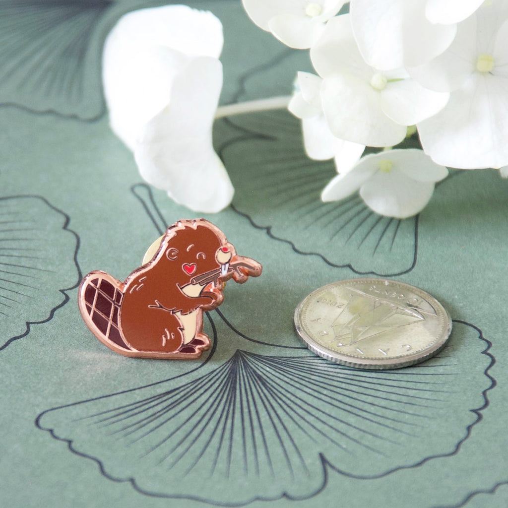 Miniature Canadian beaver pin compared to size of a dime.