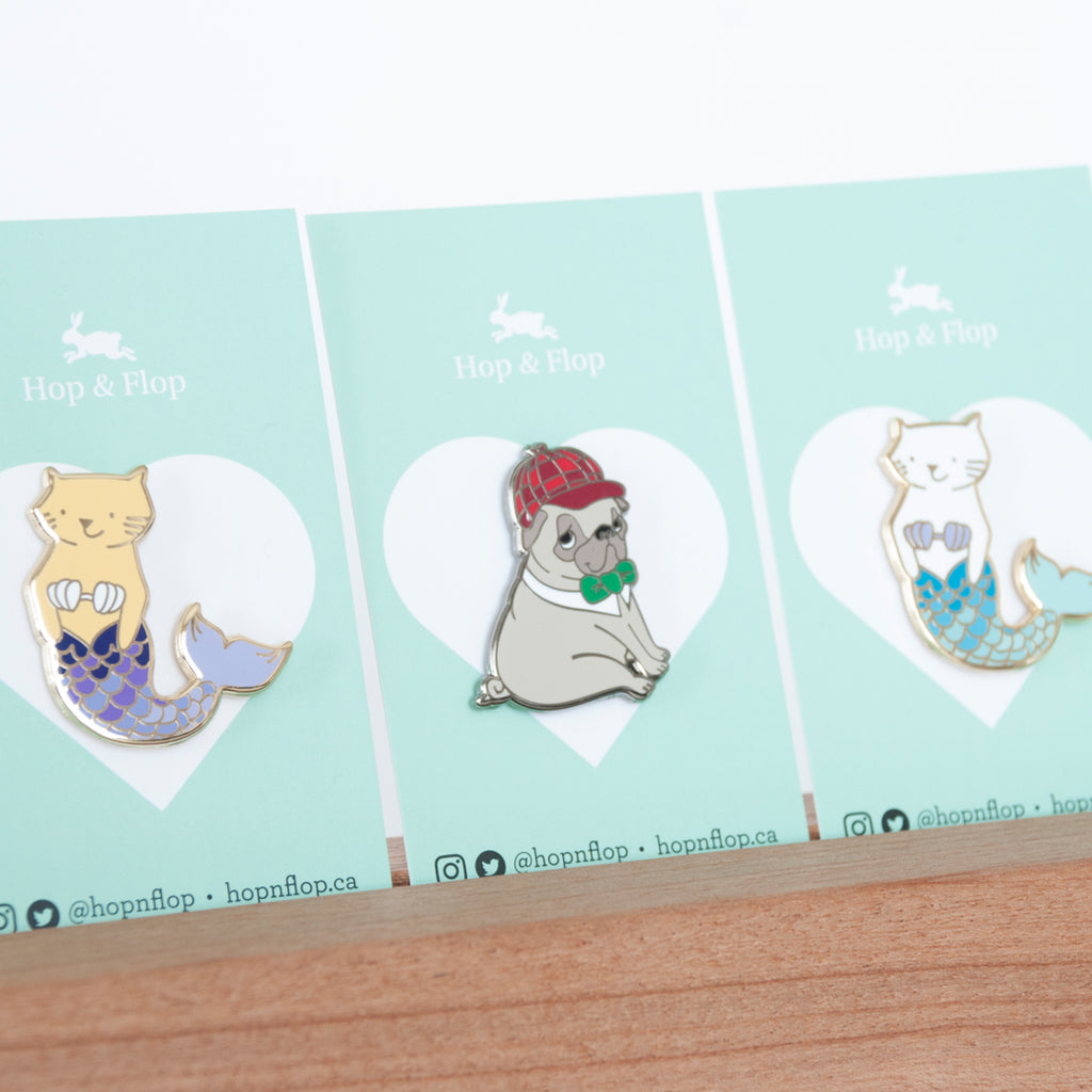 Pins shown on branded backing cards, sherlock holmes pug and cat mermaid pins