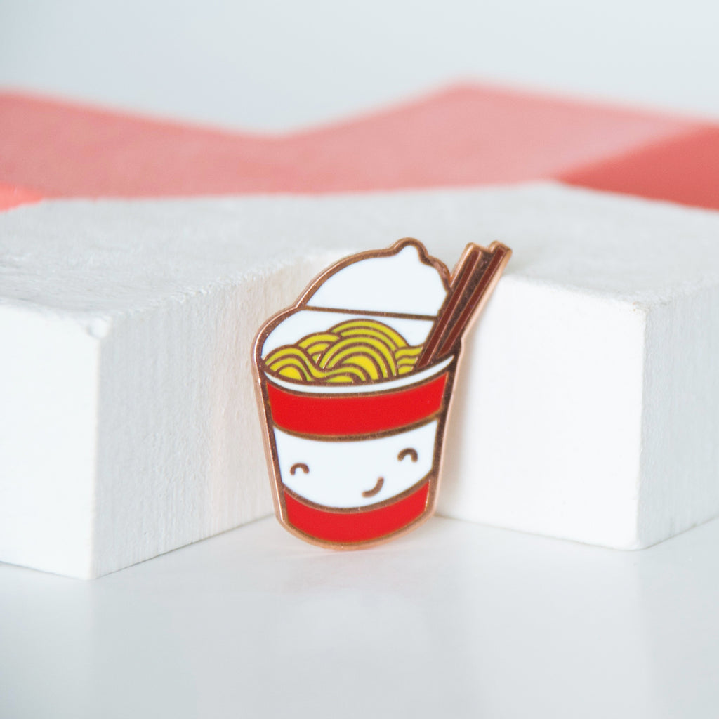 Red and white cup of instant noodles with brown chopsticks enamel pin
