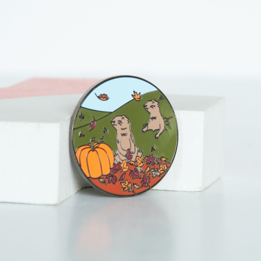 On sale canadian wildlife praire dog in a pile of fall leaves and beside a pumpkin enamel pin