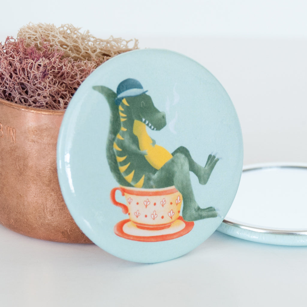 Close up of T Rex in teacup travel pocket mirror