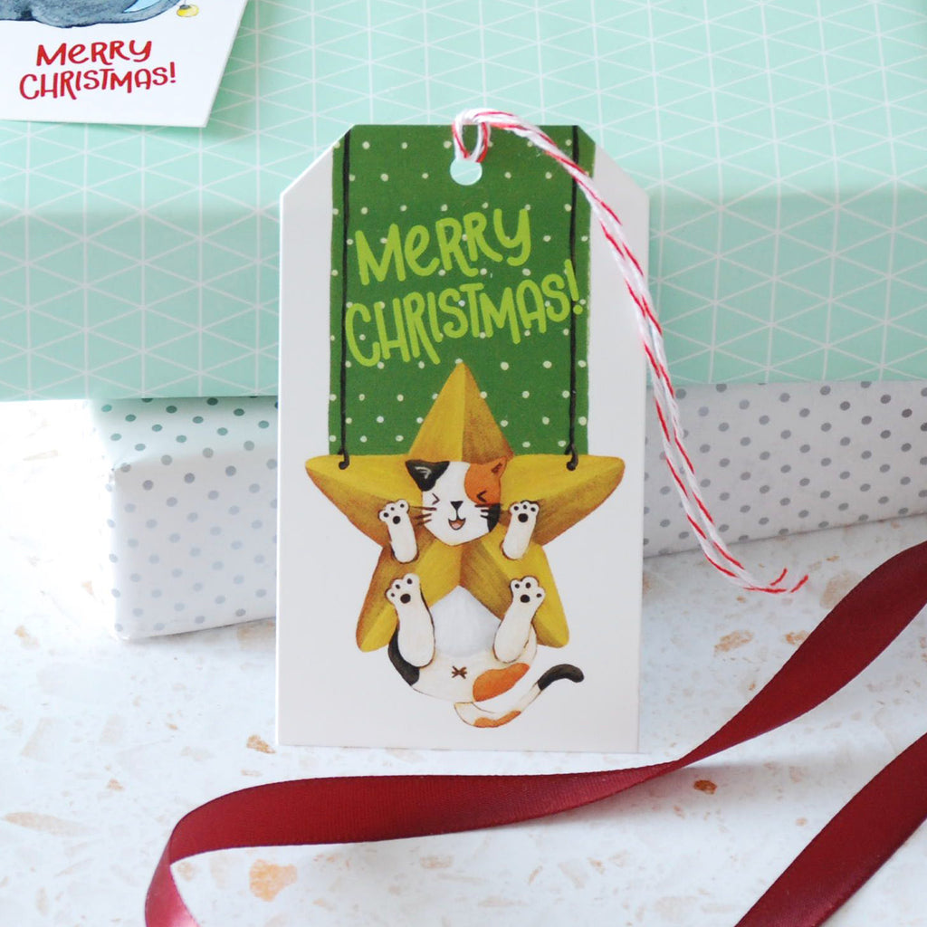 calico cat hanging from a christmas tree "Merry Christmas" gift tag