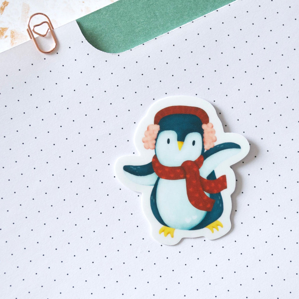 Dancing blue penguin wearing a red muff and scarf vinyl sticker