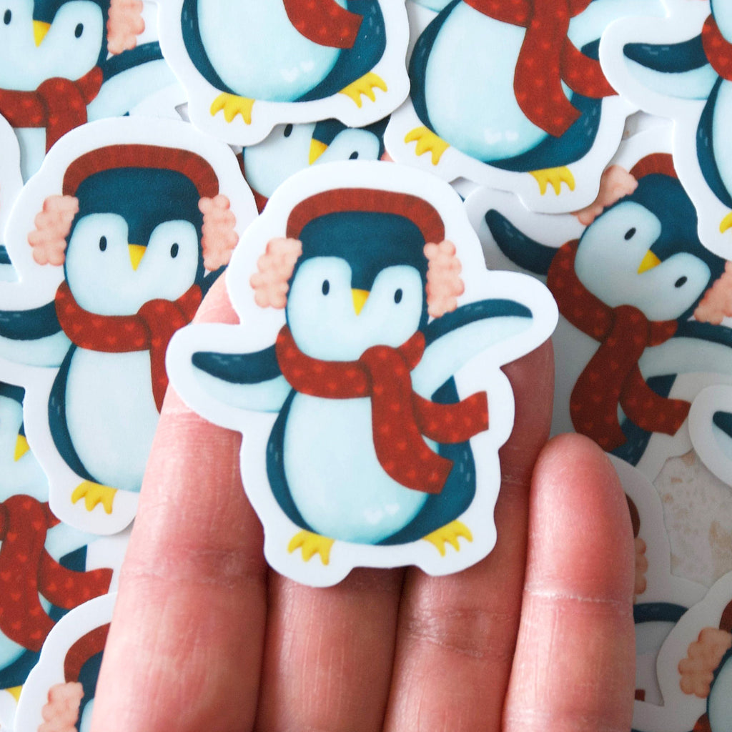 Dancing blue penguin wearing a red muff and scarf vinyl sticker